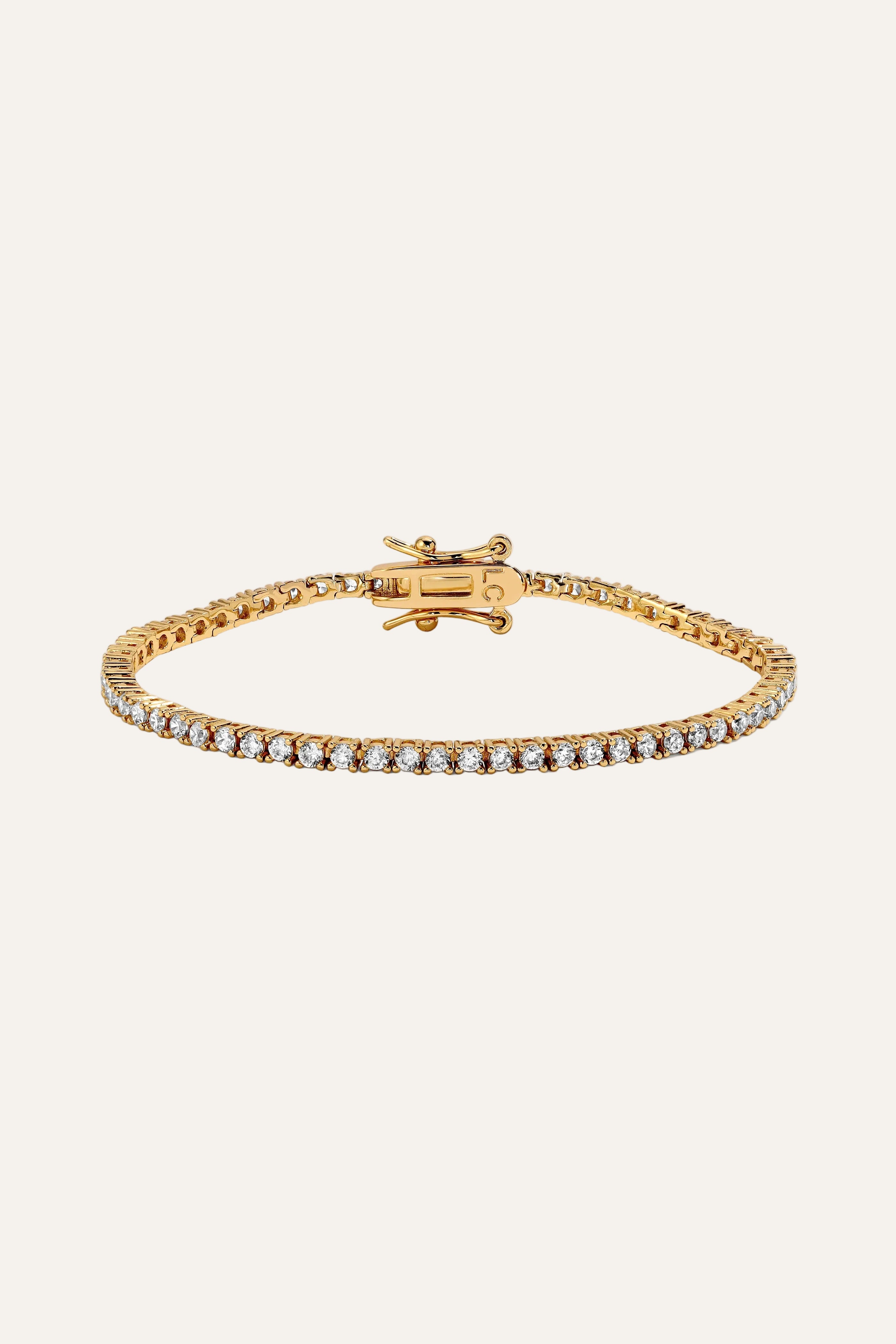Gold bracelet with clear stones on a white background