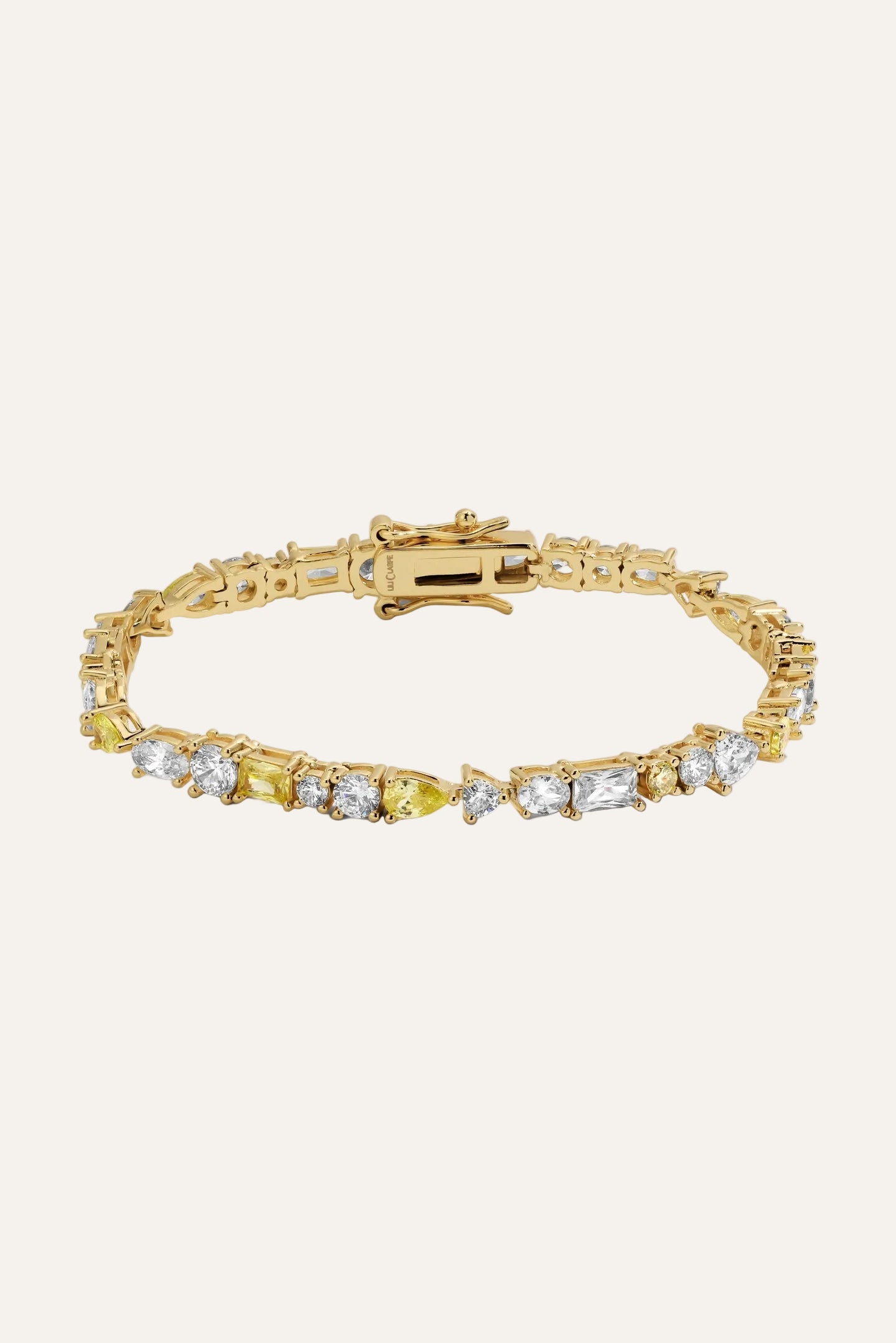 Gold bracelet with clear stones on a light gray background