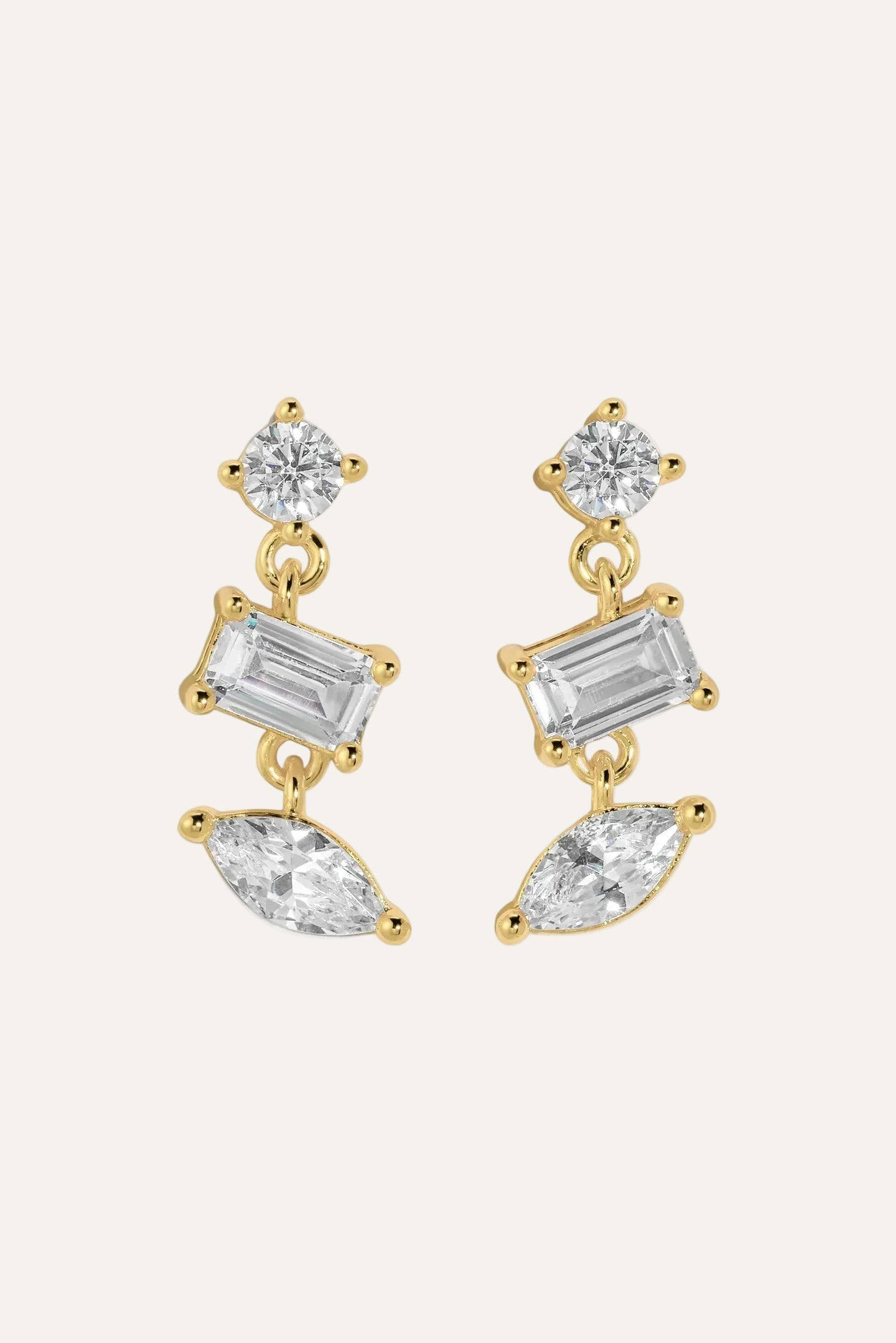 Gold earrings with clear gemstones on a white background