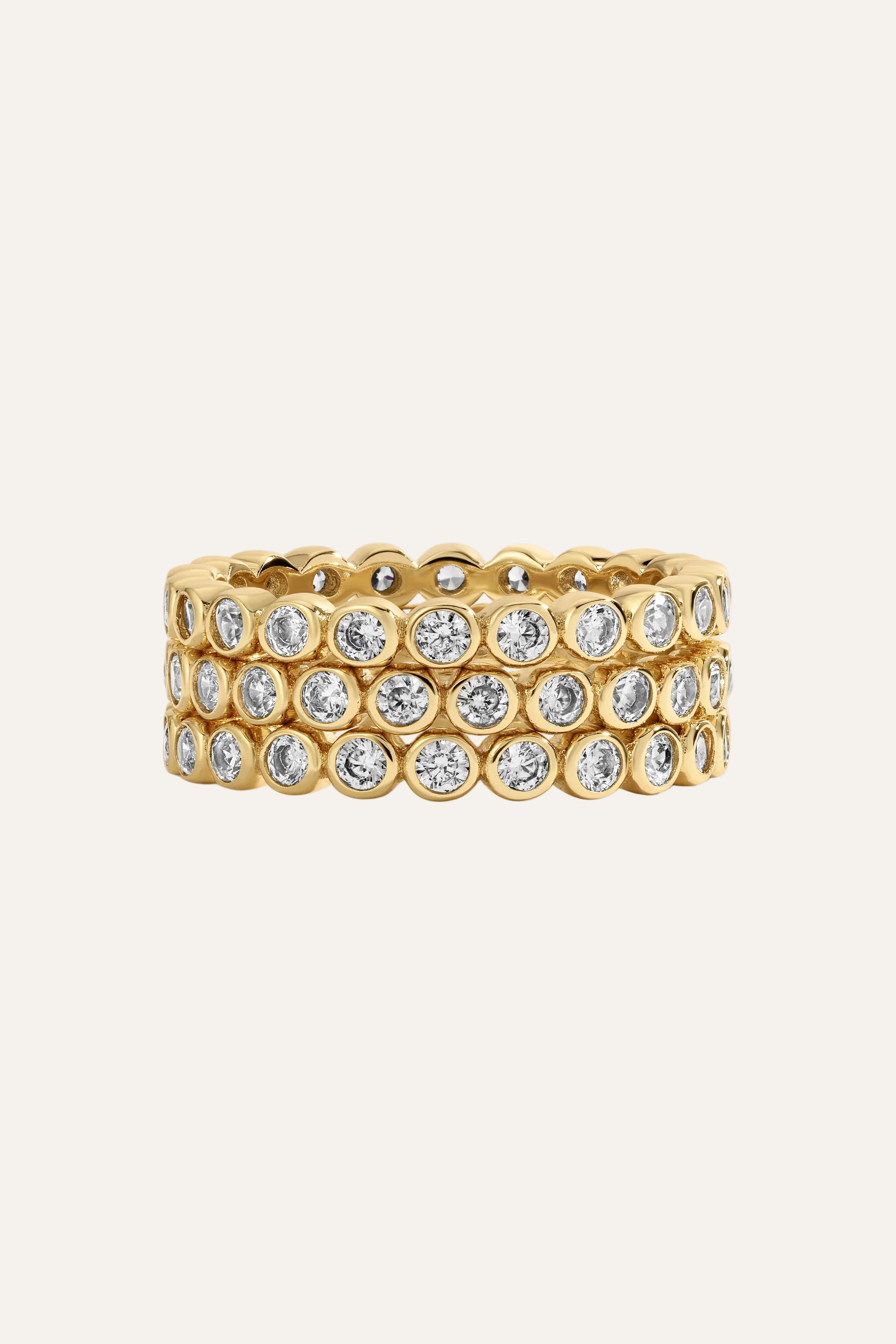 Gold ring with embedded diamonds on a light gray background
