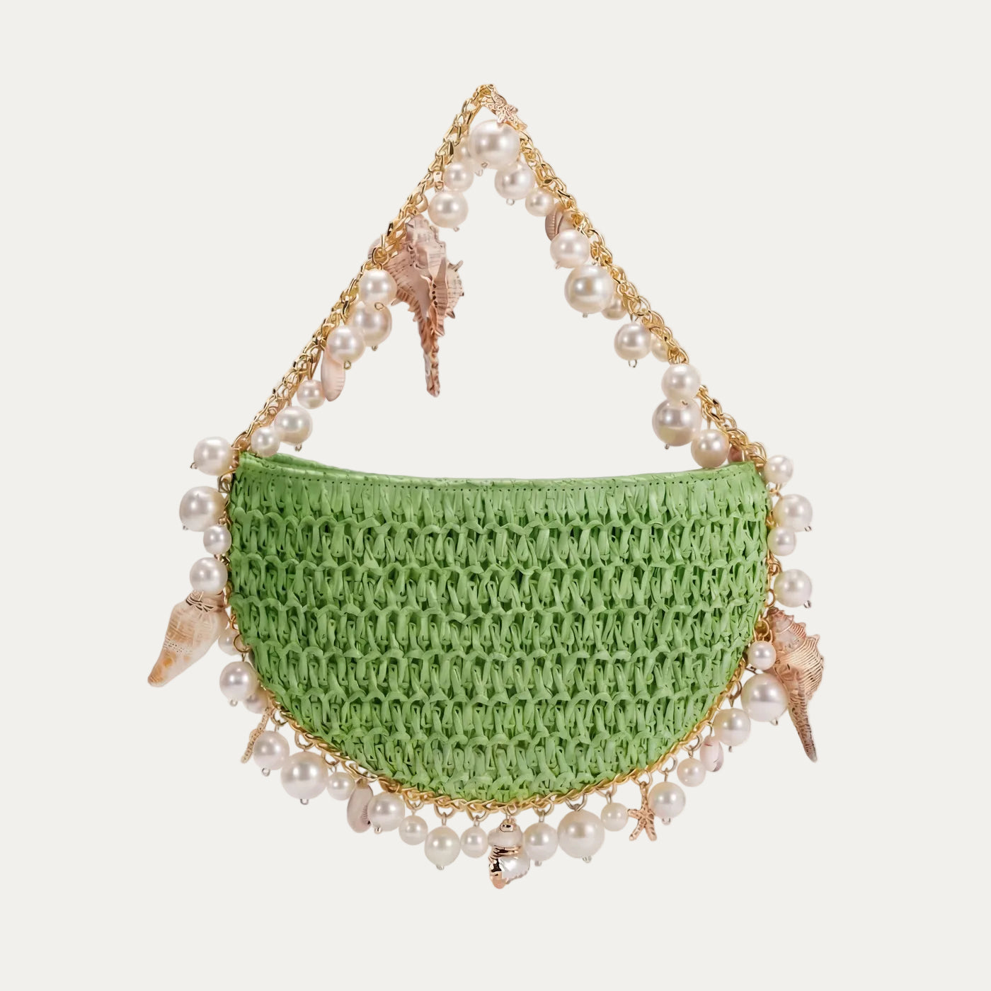Green woven handbag with pearl and shell decorations on a light background