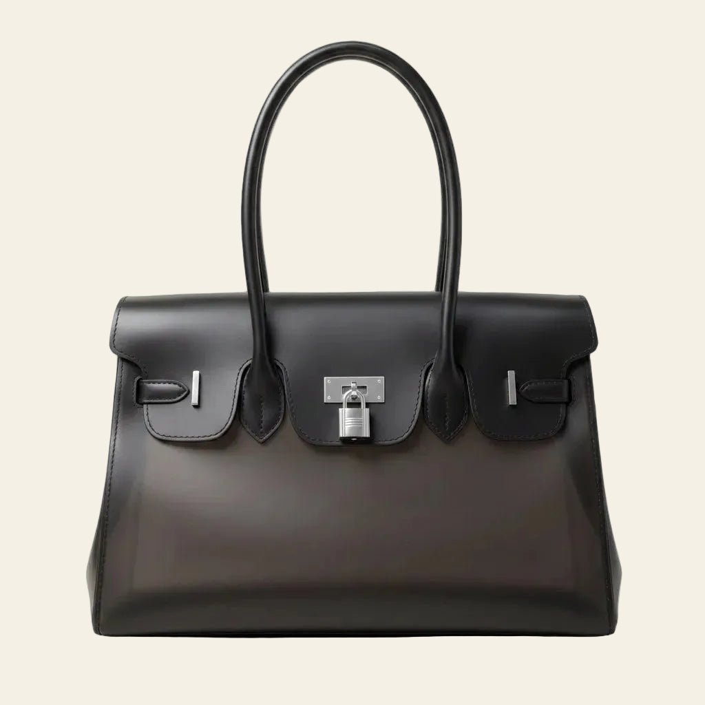 A structured black leather handbag with double top handles, a front flap, and silver-tone hardware, photographed against a plain white background.